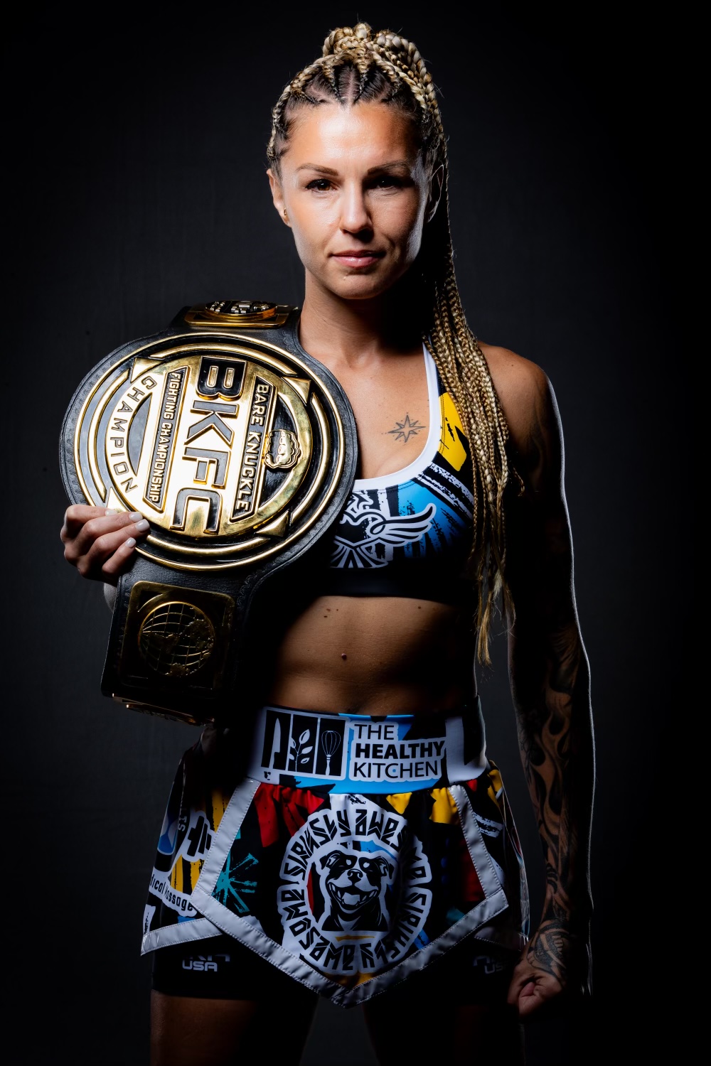 THKM-sponsored combat-sports champion wearing her championship belt