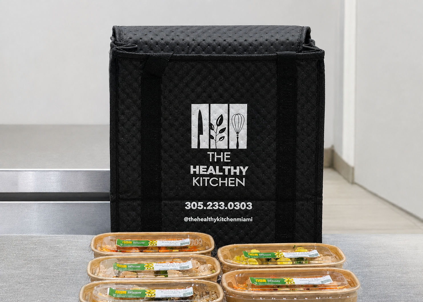 Weekly Healthy Kitchen Miami meals arranged in front of the delivery bag