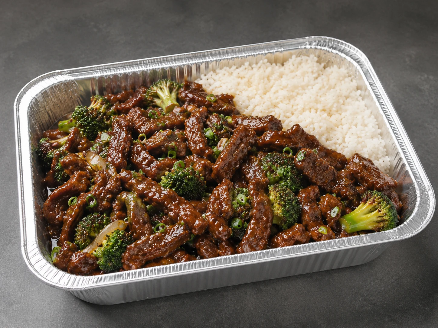 Mongolian Beef Family Bundle with glossy sauced beef, coconut rice and snap peas in a half-size aluminum tray