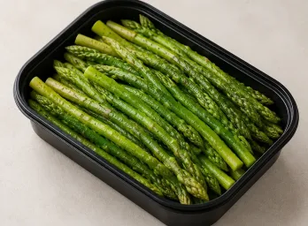 Steamed Asparagus in a black meal-prep container.