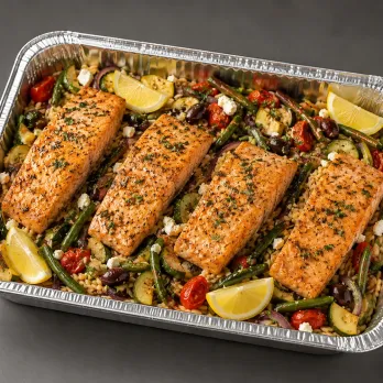 Mediterranean Salmon Family Bundle with herb-roasted salmon, lemon couscous, cucumber-tomato salad and tahini in an aluminum family tray