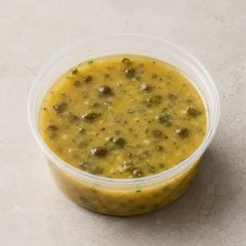 Lemon-Caper Picatta in a clear takeout sauce cup.
