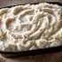 Steakhouse Mashed Potatoes sold by the ounce in a black meal-prep container.