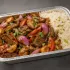 Peruvian Lomo Saltado Family Bundle with glossy beef, red onion, tomato, roasted baby potatoes and rice in an aluminum tray