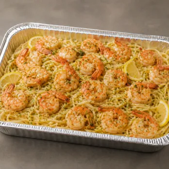 Shrimp Scampi Family Bundle with garlic-butter shrimp, thin linguine, roasted asparagus, lemon and herbs in an aluminum tray