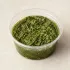 Homemade Pesto in a clear takeout sauce cup.