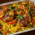 Peruvian Arroz con Pollo Family Bundle with roasted chicken, seasoned rice, peas and peppers in an aluminum tray