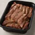 Grass Fed NY Strip in a black meal-prep container.