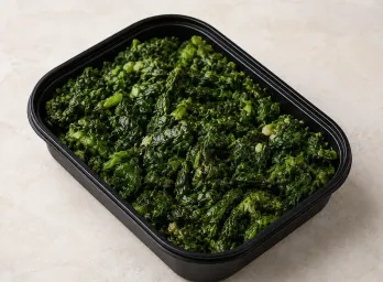 Tuscan Greens in a black meal-prep container.