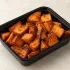 Roasted Sweet Potatoes in a black meal-prep container.