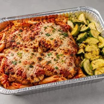 Chicken Parmesan Pasta Family Bundle in an aluminum tray with breaded chicken, marinara, mozzarella, pasta and zucchini