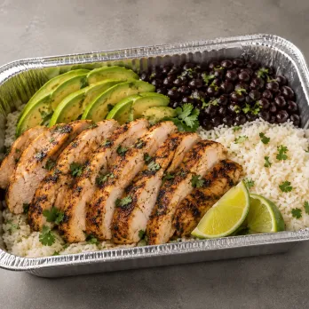 Cilantro Lime Chicken Family Bundle with grilled chicken, white rice, black beans, avocado and lime in an aluminum tray