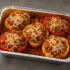 Five stuffed bell peppers with turkey, quinoa, tomato sauce and melted cheese in a half-size aluminum tray