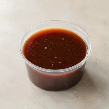 THK Mongolian Sauce in a clear takeout sauce cup.