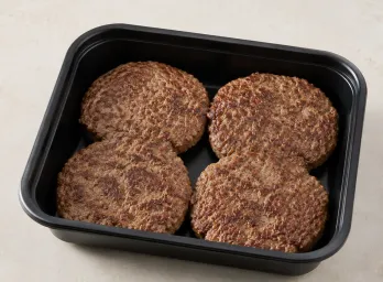 Grass-fed Beef Patties in a black meal-prep container.