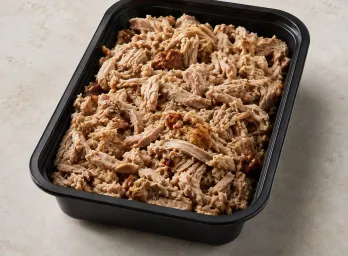 Slow Roasted Pulled Pork in a black meal-prep container.