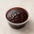 Malbec-Hibiscus Demiglace in a clear takeout sauce cup.
