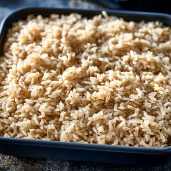 Organic Brown Rice sold by the ounce in a black meal-prep container.