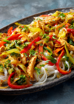 Chicken Stir Fry Family Bundle platter with chicken, colorful vegetables, and rice noodles