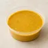 Almond Coconut Curry in a clear takeout sauce cup.