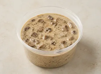 Mushroom Cream Sauce in a clear takeout sauce cup.