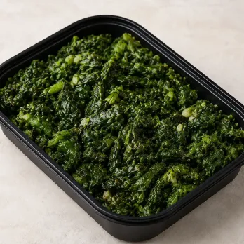 Tuscan Greens in a black meal-prep container.