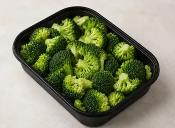 Steamed Broccoli in a black meal-prep container.