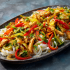 Chicken Stir Fry Family Bundle platter with chicken, colorful vegetables, and rice noodles