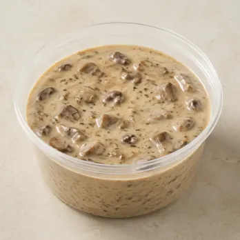 Mushroom Cream Sauce in a clear takeout sauce cup.