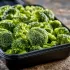 Steamed Broccoli sold by the ounce in a black meal-prep container.