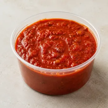 Homemade Marinara in a clear takeout sauce cup.