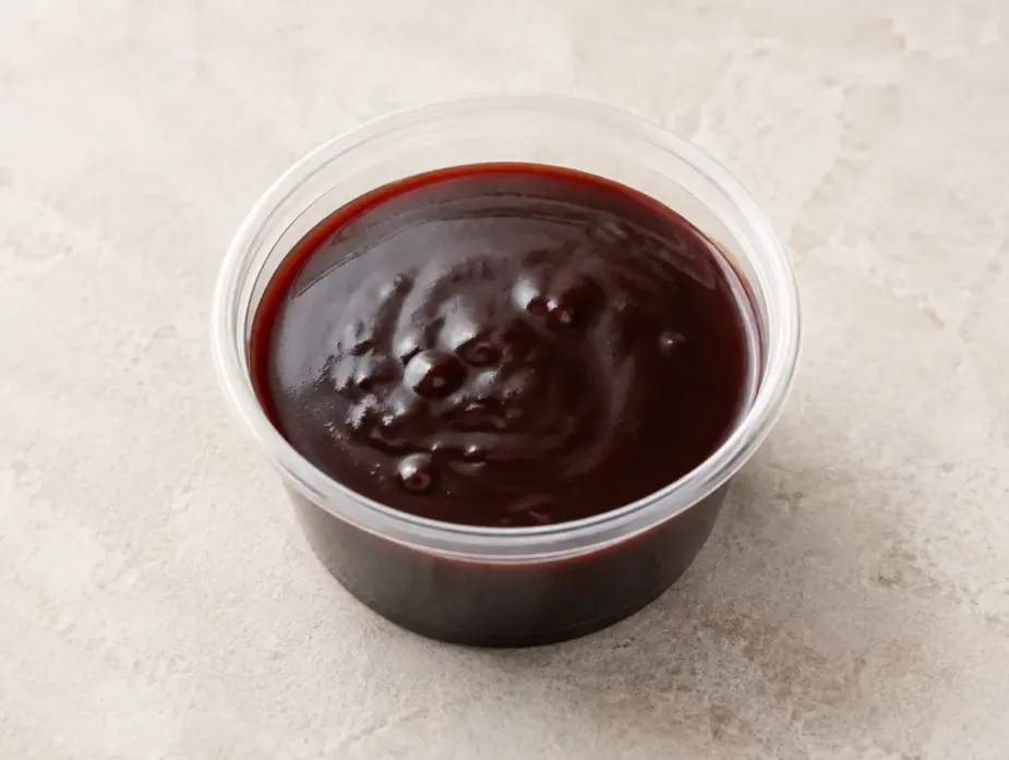 Malbec-Hibiscus Demiglace in a clear takeout sauce cup.