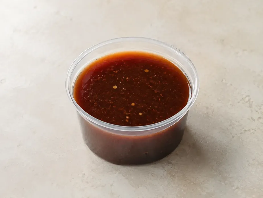THK Mongolian Sauce in a clear takeout sauce cup.