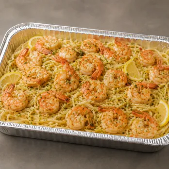 Shrimp Scampi Family Bundle with garlic-butter shrimp, thin linguine, roasted asparagus, lemon and herbs in an aluminum tray